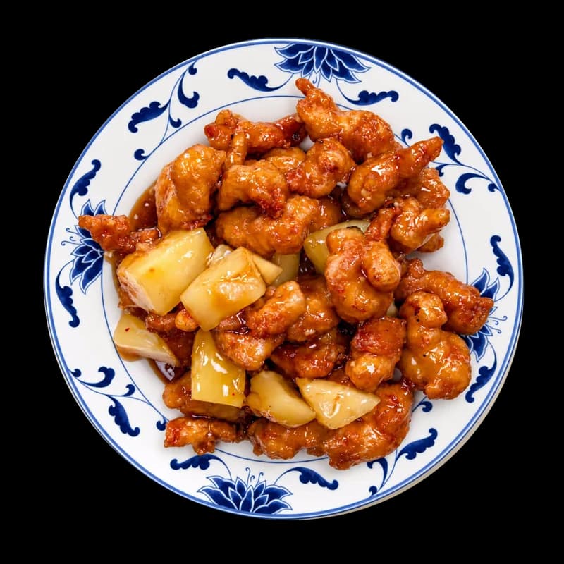 Orange chicken in sweet orange sauce on a blue and white plate